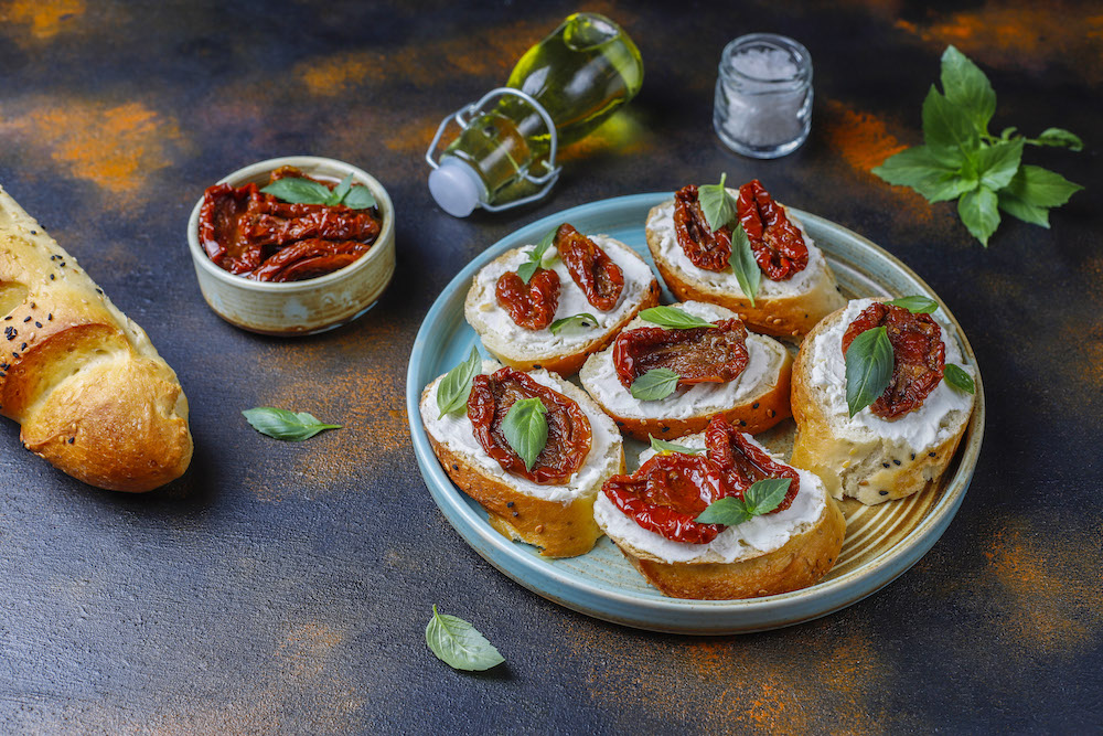 Italian sandwiches – bruschetta with cheese, dry tomatoes and basil.